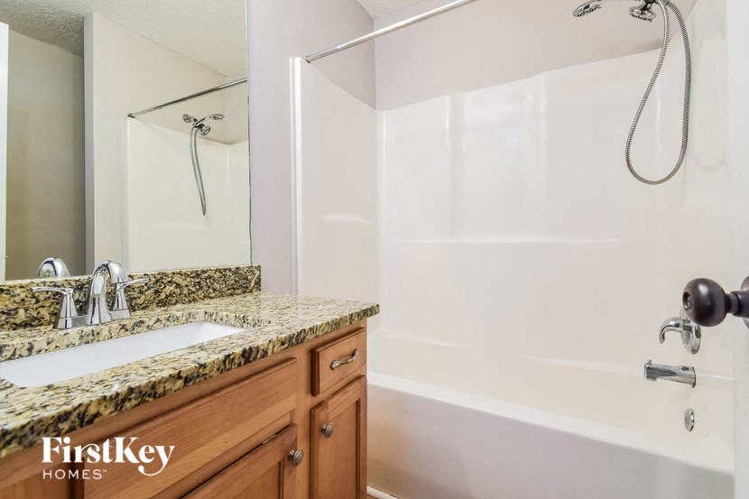 a bathroom with a shower and a sink and a mirror
