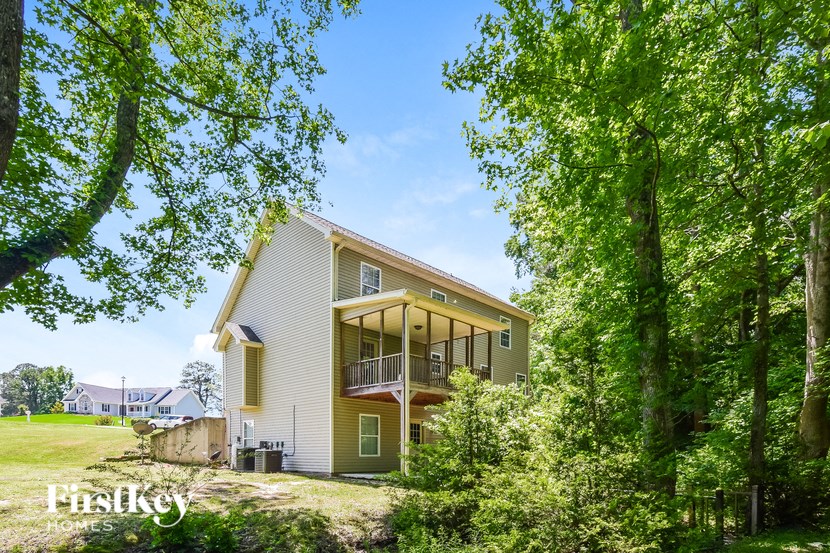 the back of a house with trees and a yard