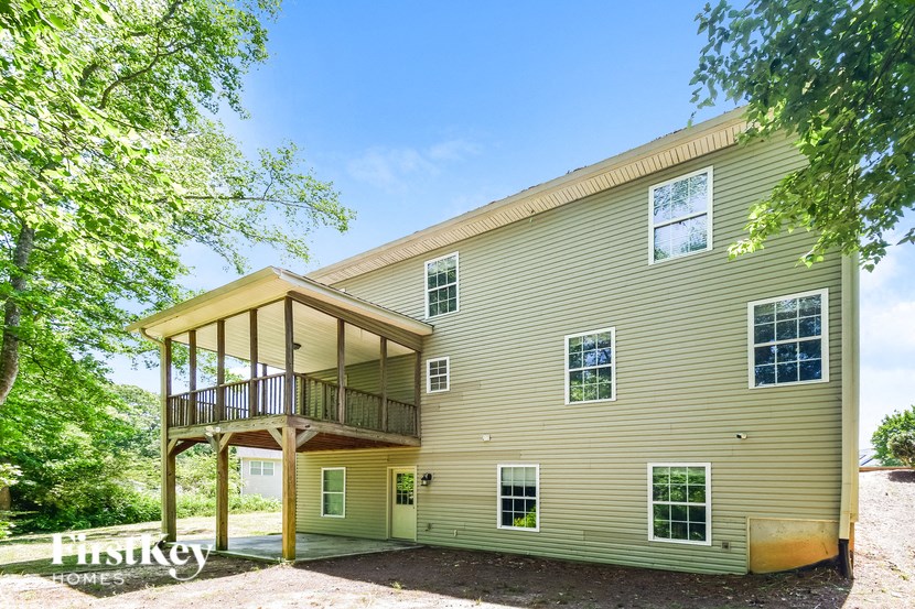 the back of a house with a balcony and a deck