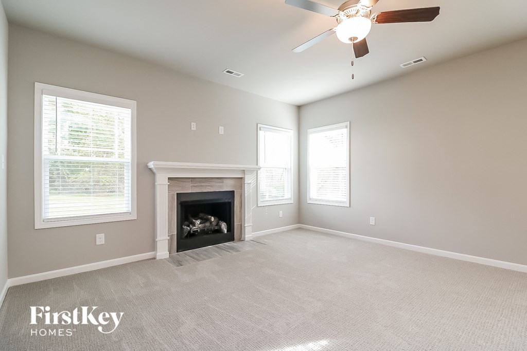 a living room with a fireplace and a ceiling fan