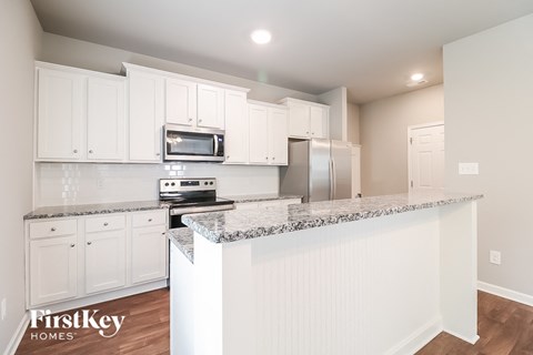 a kitchen with white cabinets and granite counter tops