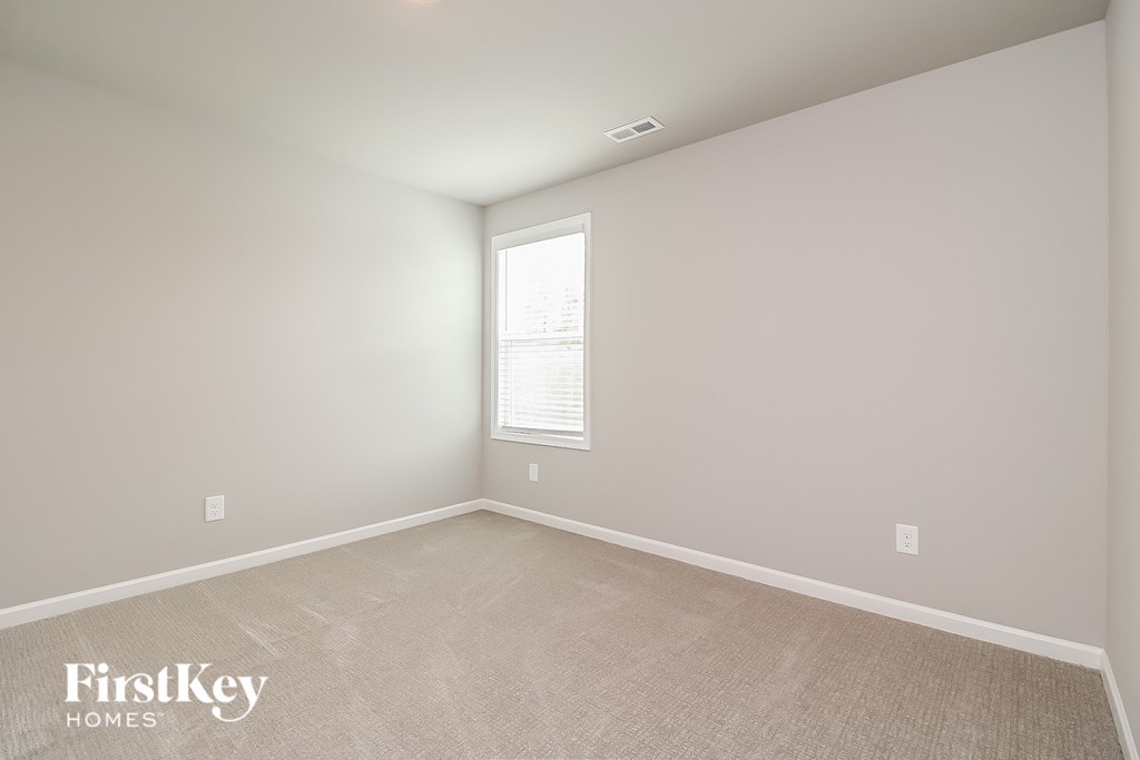 a bedroom with a carpeted floor and a window
