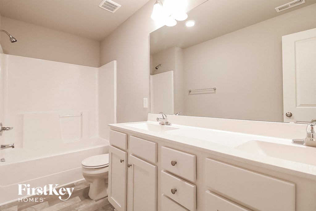 a white bathroom with a white sink and toilet
