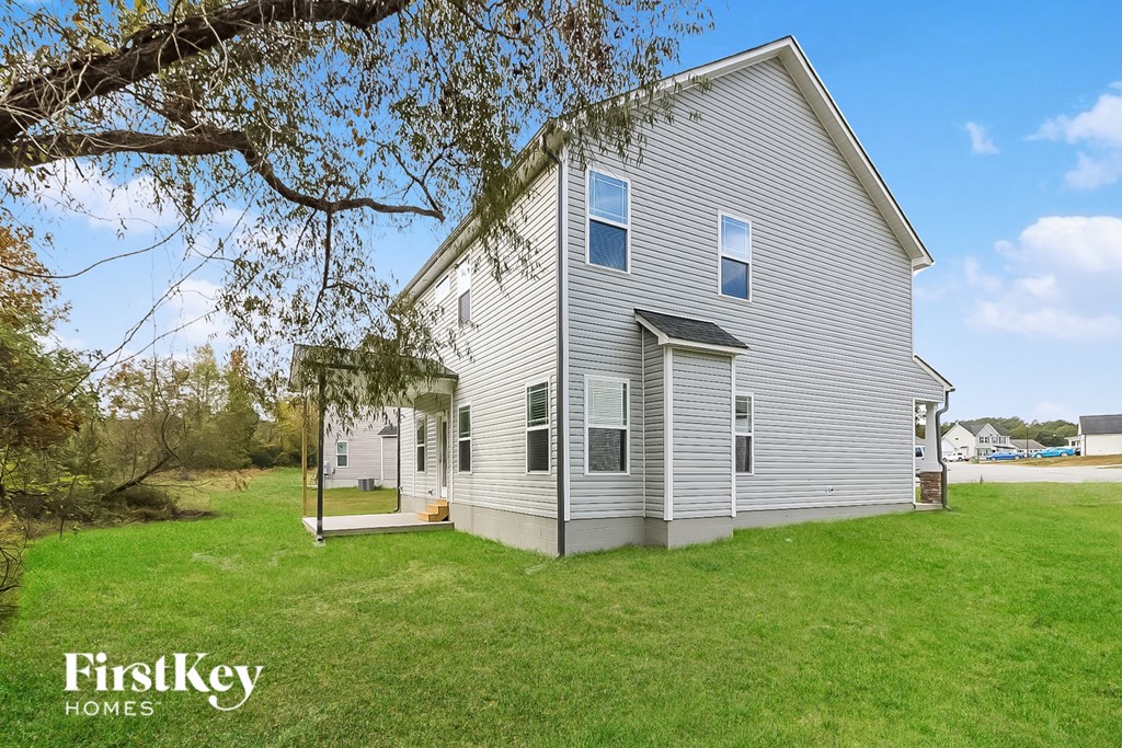 a white house with a yard and a tree