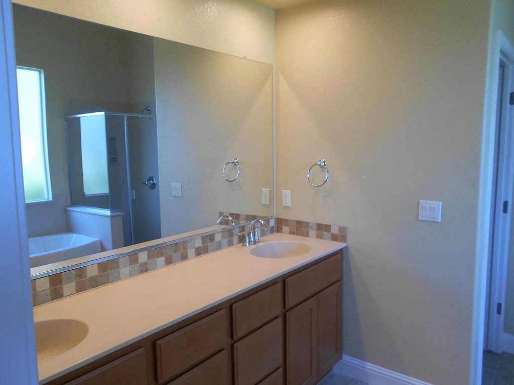 a bathroom with two sinks and a large mirror