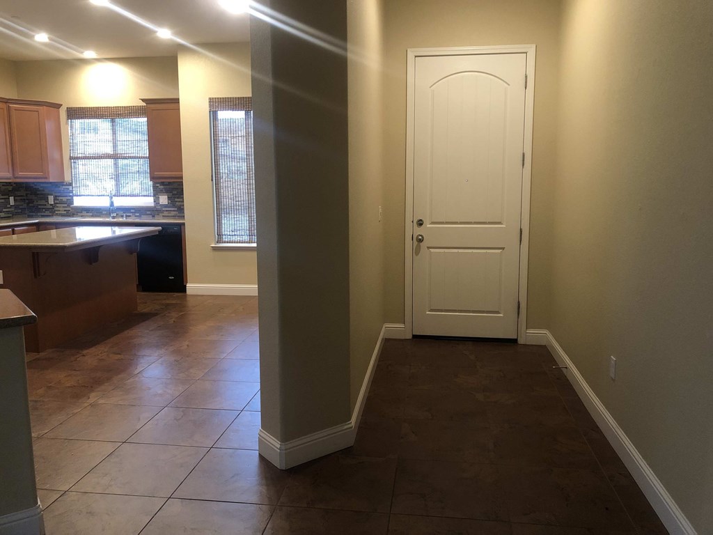 an empty kitchen with a white door in the middle