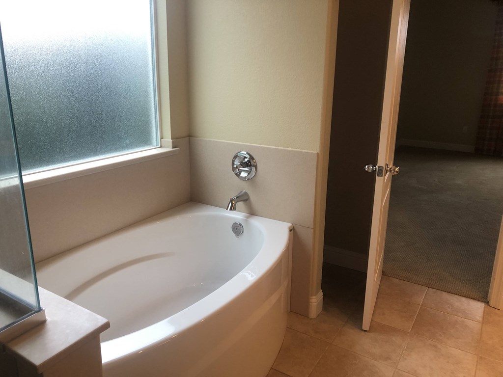 a bathroom with a tub and a window