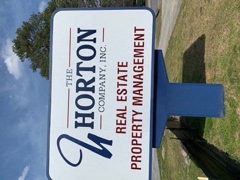 a blue and white street sign sitting on top of a field