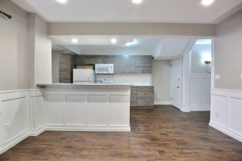 A kitchen with white cabinets and a white fridge.