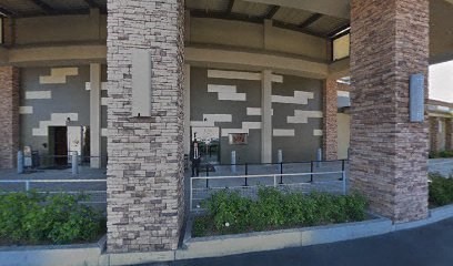 A building with a grey and white facade supported by two stone pillars.