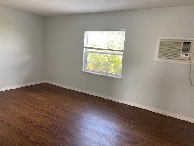 an empty room with a window and wooden floors