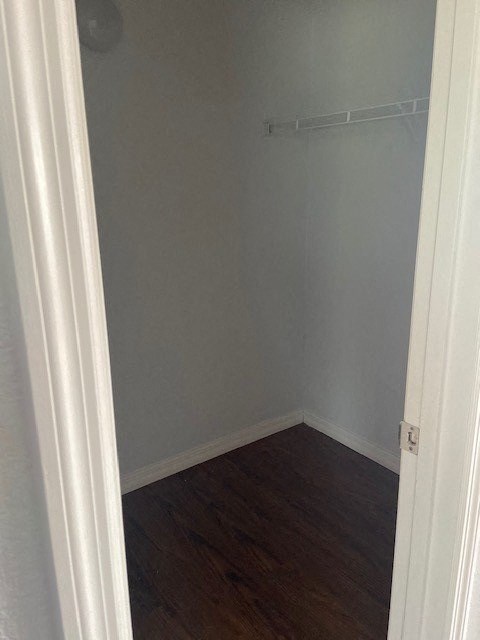 a small room with a wooden floor and a white closet