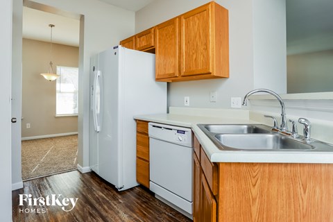 a kitchen with white appliances and wooden cabinets and a white refrigerator