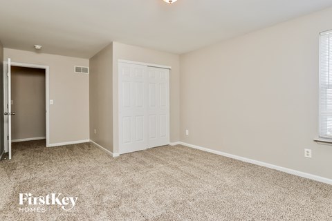 a bedroom with a white door and a carpeted floor