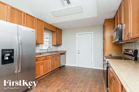 a kitchen with wooden cabinets and a stainless steel refrigerator