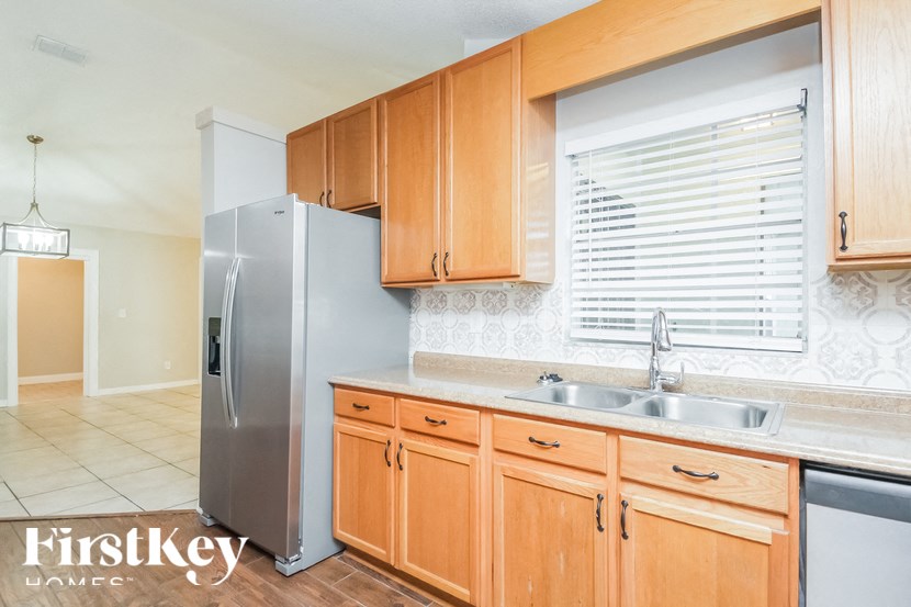 a kitchen with wooden cabinets and a stainless steel refrigerator