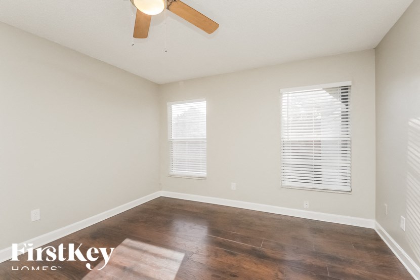 a living room with wood floors and a ceiling fan