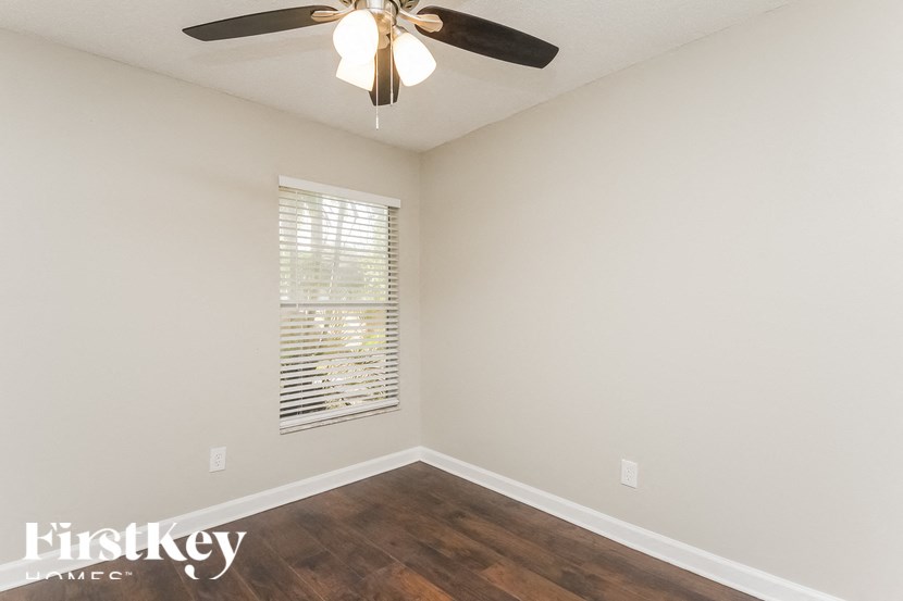a empty room with a ceiling fan and a window