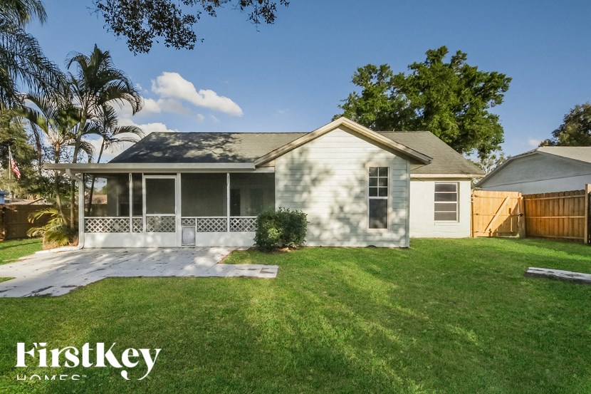a small white house with a lawn and a porch