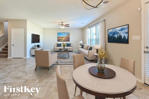A well-lit living room with a dining table and chairs.