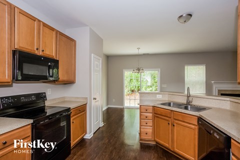 a kitchen with wooden cabinets and a black stove and a sink