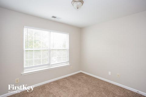a bedroom with a carpeted floor and a large window