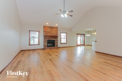 the living room with wood floors and a fireplace