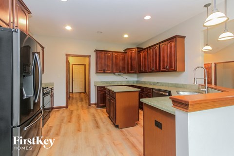 a kitchen with wood flooring and stainless steel appliances and wooden cabinets