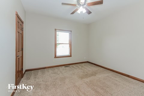 a bedroom with a carpeted floor and a ceiling fan