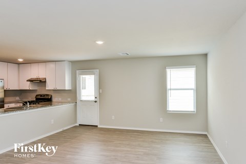 A spacious room with a kitchen area and a window.