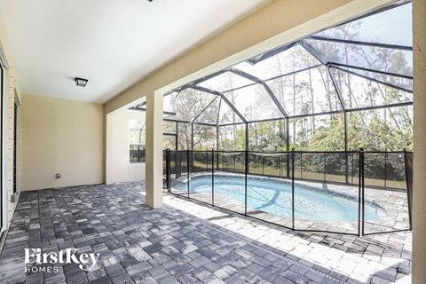 the pool is in the back of the house with a large window and a fence