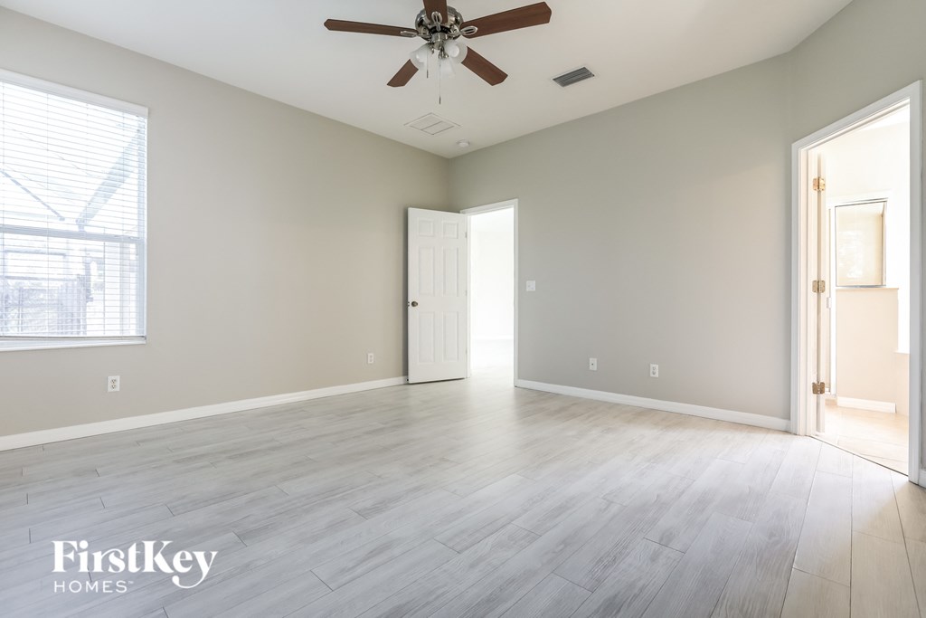 a clean and empty living room with a ceiling fan