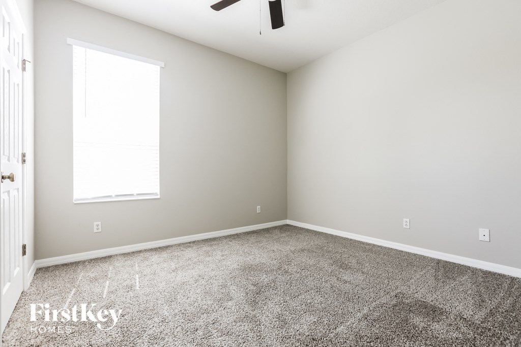 an empty room with carpet and a window