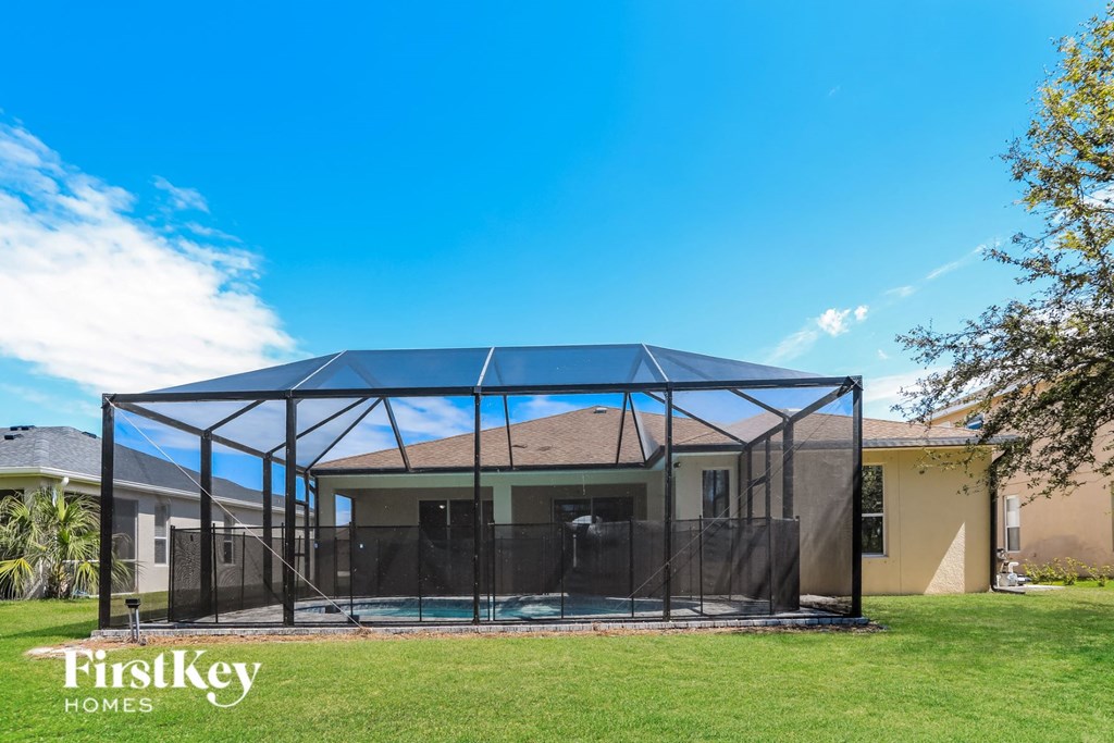 a patio with a glass enclosure in front of a house