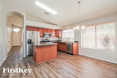 A kitchen with wooden floors and a refrigerator.