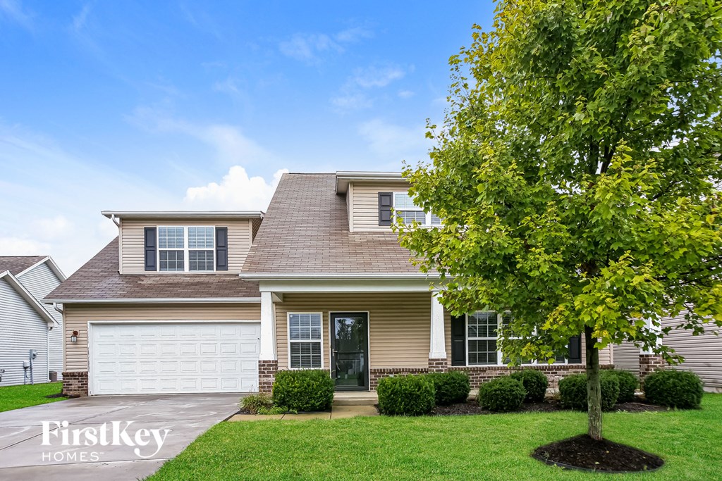 a beige house with a tree in front of it