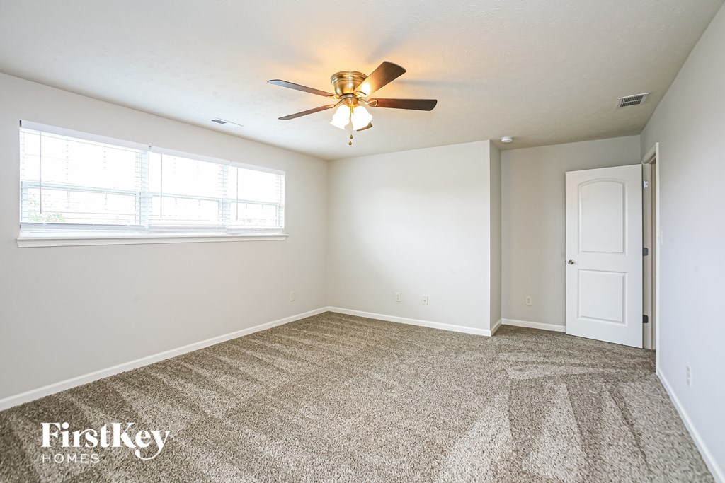 the living room of an empty house with a ceiling fan