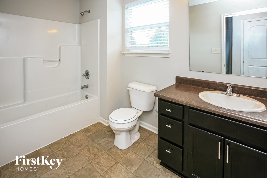 a bathroom with a toilet and a sink and a bath tub