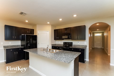 a kitchen with black cabinets and a granite counter top