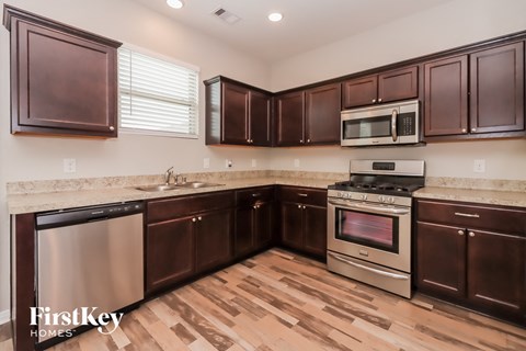 A kitchen with brown cabinets and a stainless steel dishwasher.