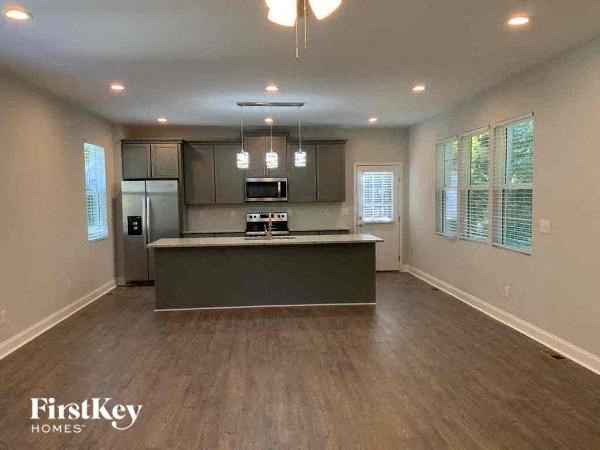 A spacious kitchen with wooden floors and a center island.