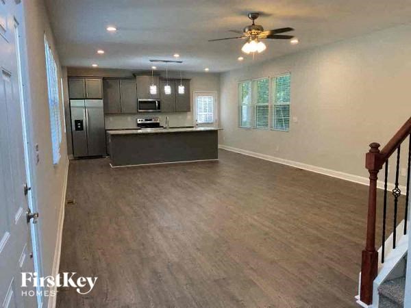 A spacious kitchen with a refrigerator, microwave, and oven.