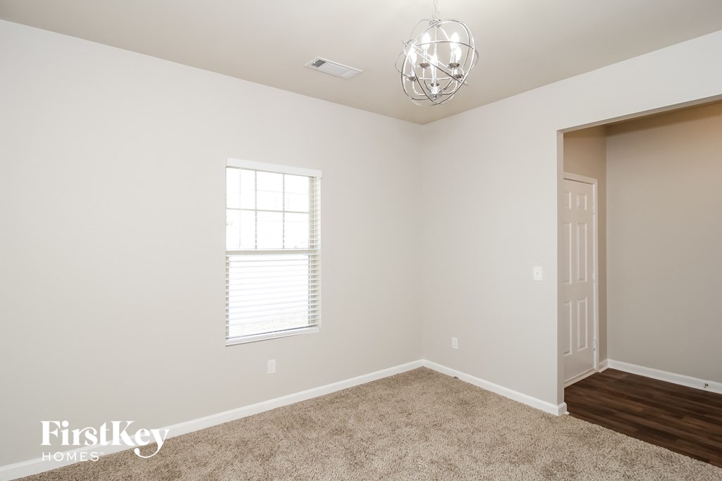 a bedroom with white walls and a window and a door
