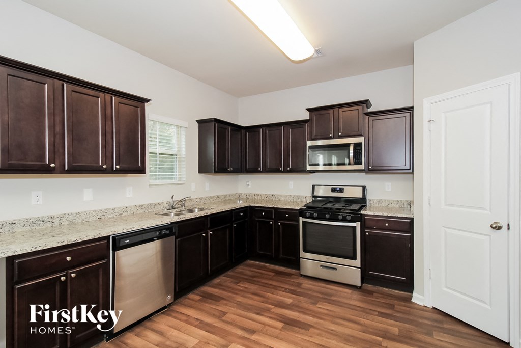 a kitchen with dark wood cabinets and granite counter tops
