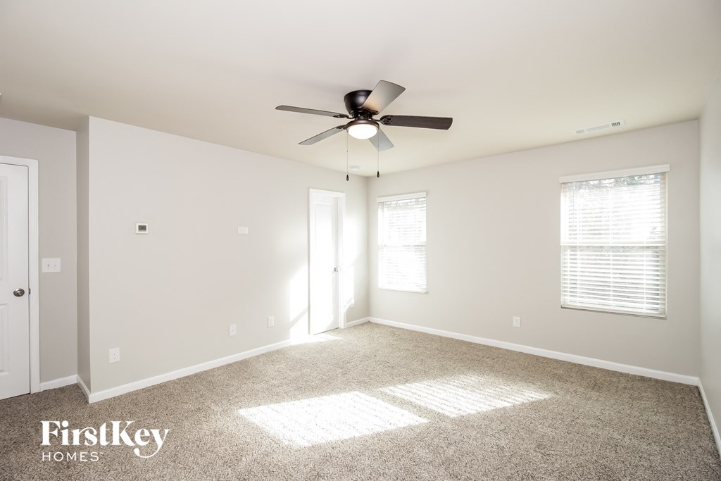 a living room with carpet and a ceiling fan