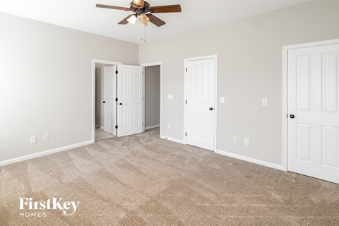 a living room with carpet and a ceiling fan