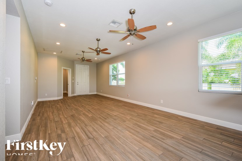 A spacious room with wooden flooring and a ceiling fan.