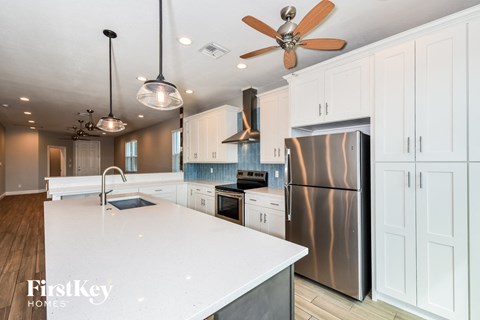 a white kitchen with stainless steel appliances and white cabinets
