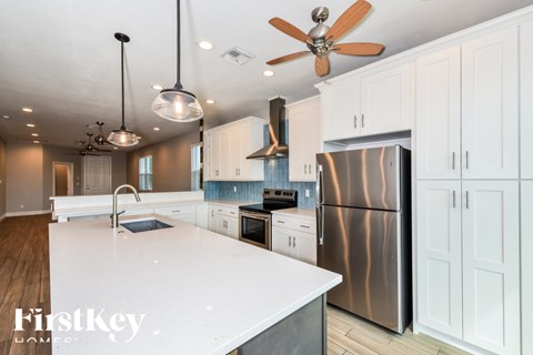 A modern kitchen with a stainless steel refrigerator and white countertops.