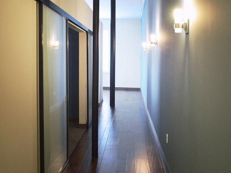 a hallway with glass doors and a tiled floor